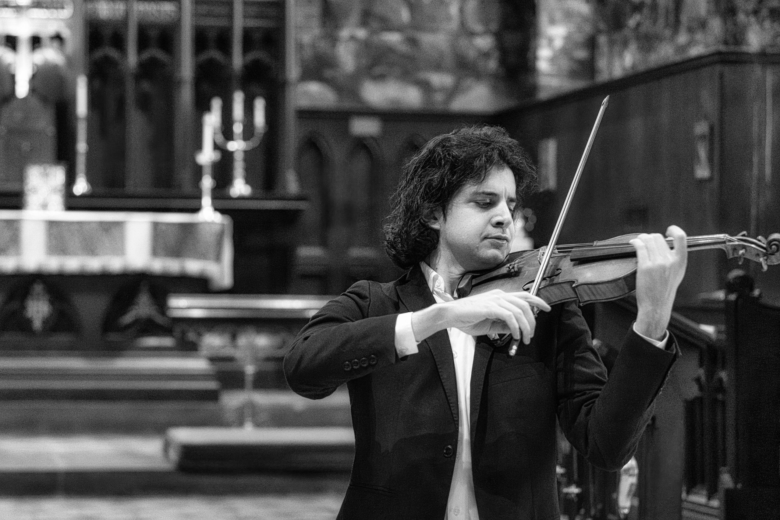 Michael Tropepe performing violin in a church, black-and-white photograph